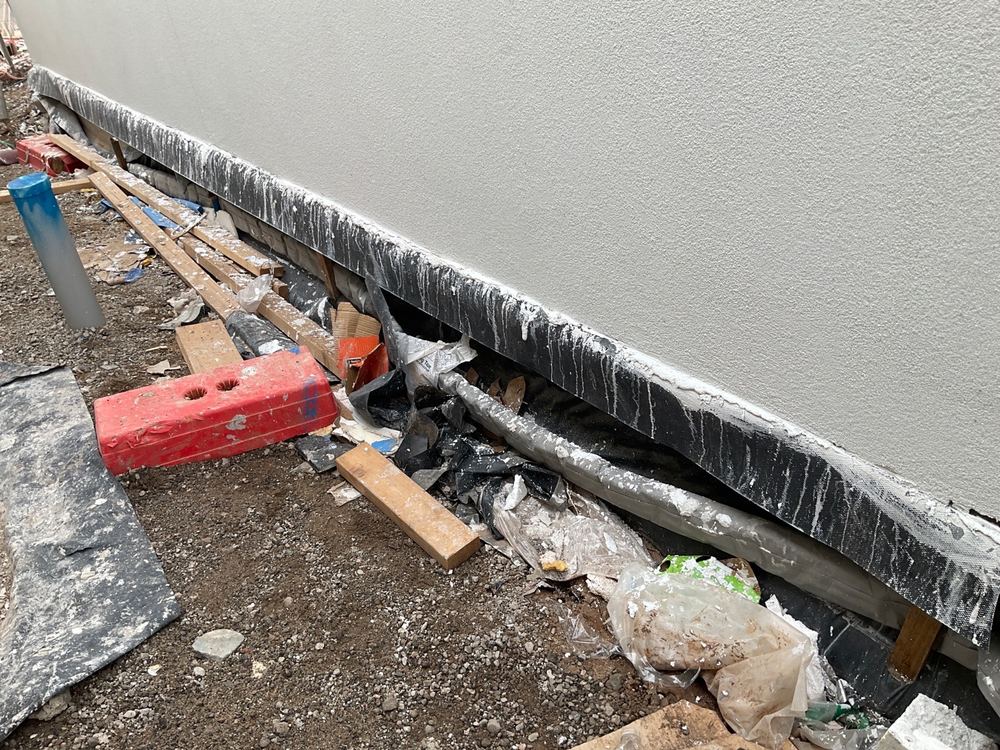 Garage strip drain bedded unevenly, so water can sit in the channel, found during a fixing inspection in Mambourin