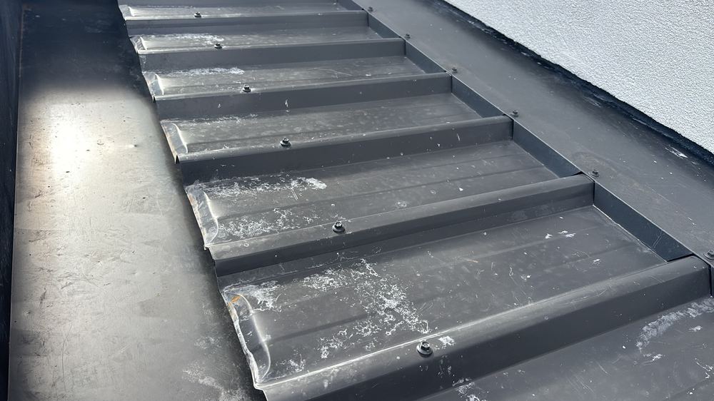 Metal roof sheets scratched and dented, shortening the life of the coating, found during a pre-handover inspection in Mambourin