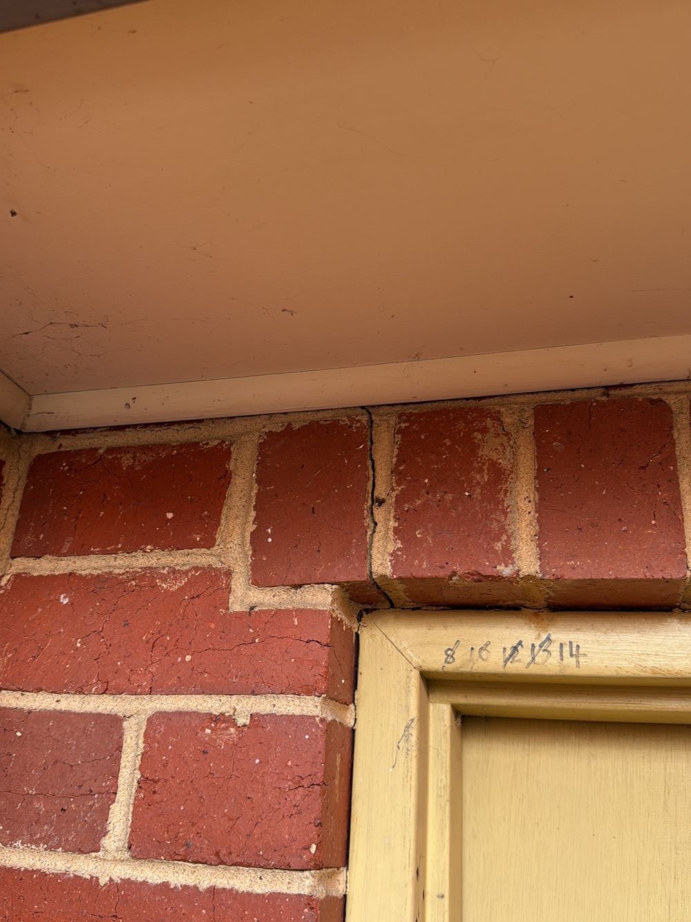Cracking above the rear garage door where no lintel appears to carry the bricks, found during a pre-purchase inspection in Newport
